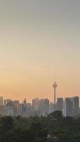 timelapse vertical paysage vue du centre-ville de kuala lumpur quartier du centre-ville avec de nombreux gratte-ciel bâtiment tour de style moderne tours avec beau coucher de soleil vanille lever du soleil ciel crépusculaire