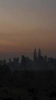 vertical timelapse landscape view of kuala lumpur city center downtown district area with many skyscraper building highrise modern style towers with beautiful vanilla sundown sunrise twillight sky video