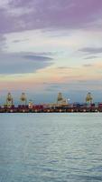 vertical timelapse of  deep sea port with cargoship loading and unloading with many cargo containers,import and export freight transportation by container ship video