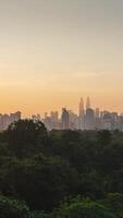 vertical timelapse landscape view of kuala lumpur city center downtown district area with many skyscraper building highrise modern style towers with beautiful vanilla sundown sunrise twillight sky video