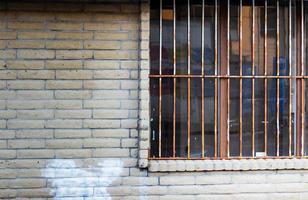 Old abandoned building window with rusty bars photo