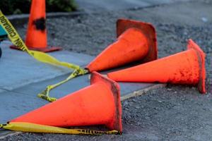 conos de tráfico naranja caídos y cinta de precaución foto