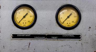 Vintage antique automotive machine shop vacuum gauges on a silver sheet metal plate photo