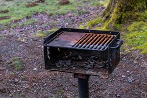 Park picnic area barbeque grill with leaves and a tree photo