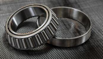 Automotive tapered roller bearing and race on carbon fiber cloth photo