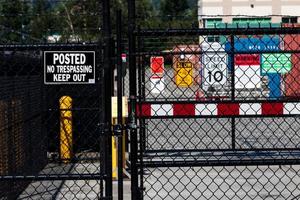 Security gate with various caution and admittance signs photo