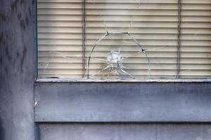 Abstract old building storefront window with bullet hole photo