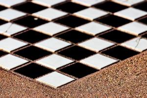 Tiles chess board inlaid on a concrete table photo