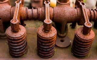 Vintage antique automotive cylinder head rocker shaft and arms covered in orange rust photo