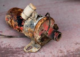 Vintage antique automotive ignition coil with bracket and suppression condenser with rust and peeling paint photo