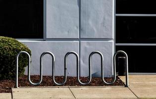 Curvy bike rack in front of a white wall photo