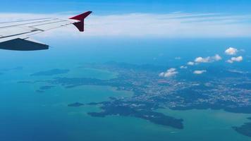 vista en primera persona desde la ventana del avión al océano y la isla. concepto de vacaciones y viajes, fronteras cerradas video