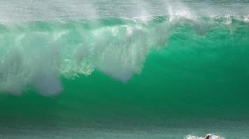 onda azul do mar rola em terra e desmorona com salpicos e espuma, close-up tiro video