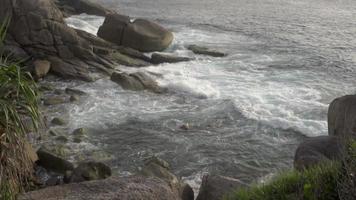 zee golven Botsing Aan een rotsachtig oever, langzaam beweging. top visie, zee kust en sterk golven video