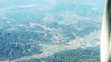 vue à la première personne depuis la fenêtre de l'avion vers les montagnes. voler haut au-dessus d'un terrain montagneux video