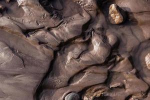 orilla del río glacial con barro de arena de limo negro húmedo foto