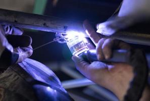 Man tig welding with brilliant bright white star-burst blooms photo