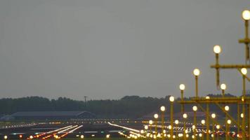 Cinematic shot of the runway in the early morning illuminated by landing lights. Tourism and travel concept video