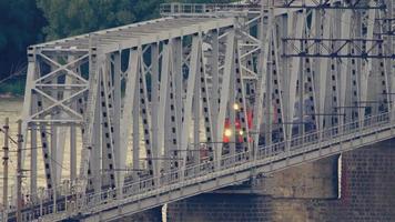 Zug auf der Brücke über den Fluss ob an einem Sommerabend video