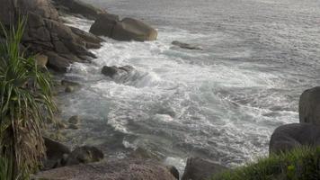 Panoramablick auf die Meereswellen an einem windigen Tag gegen die Felsen schlagen video