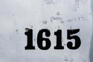 Street numbers 1615 on white chipped faded worn paint photo