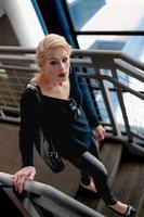 Attractive blonde woman walking down a flight of stairs in a city building. photo