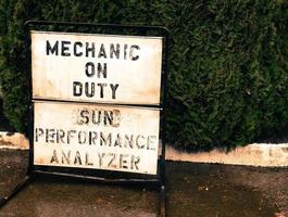 Small town mechanic on duty sign on a sidewalk photo
