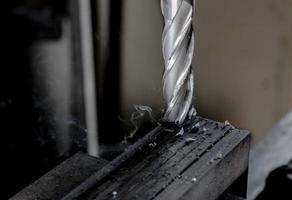 Bridgeport CNC end mill finishing a stack of steel plate with metal filings chips trailing photo