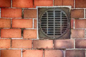 Old storm drain on a brick walkway photo