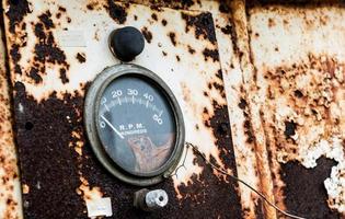 RPM gauge on an old rusty panel with chipping peeling paint flaking away photo