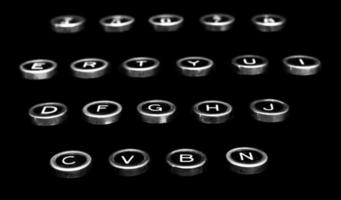 teclas de máquina de escribir antiguas antiguas en un fondo negro foto