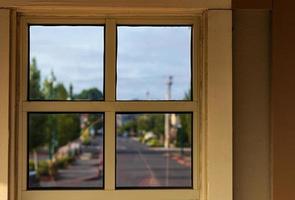 Looking out an urban window with clouds and a blue sky photo