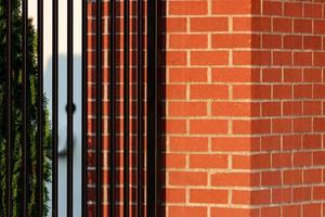 Wrought iron fence attached to red brick post photo