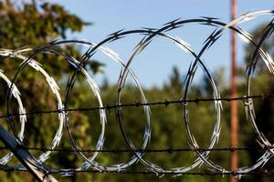 Razor wire fence shining in the sun photo