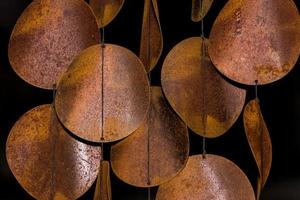 Rusty orange and yellow wind chime discs hanging on strings photo