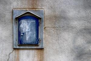 Abstract building wall with antique fire alarm photo