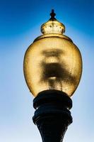 Glass street lamp head on a cast iron post photo