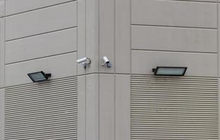 2 security cameras on the side of a building photo