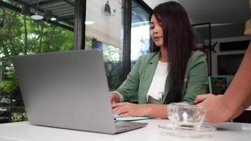 Young woman sitting in a cafe with laptop and paying with credit card, smart payment, contactless payment concept video