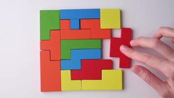 Logical thinking and finishing task concept. Woman hand adding last missing wooden block to finish puzzle video