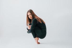 tomando un descanso. mujer joven en ropa deportiva haciendo gimnasia en el interior foto