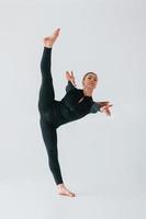 Slim body type. Young woman in sportive clothes doing gymnastics indoors photo