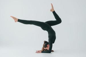 Healthy person. Young woman in sportive clothes doing gymnastics indoors photo