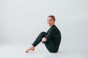 vista desde el lado. mujer joven en ropa deportiva haciendo gimnasia en el interior foto