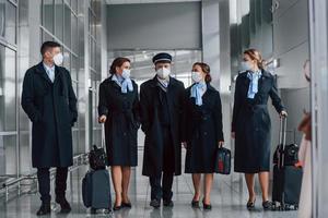 la tripulación del avión con uniforme de trabajo está junta al aire libre en el aeropuerto foto