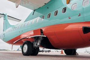 vista de cerca de las ruedas. avión turbohélice estacionado en la pista durante el día foto