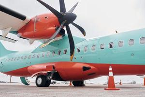 vista de cerca de las ruedas. avión turbohélice estacionado en la pista durante el día foto