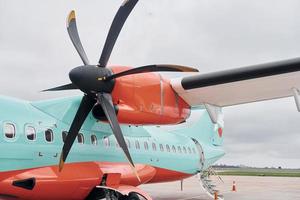 Retro style. Turboprop aircraft parked on the runway at daytime photo