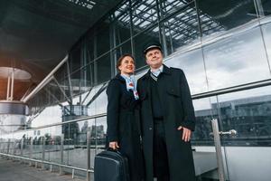 hombre con mujer. la tripulación del avión con uniforme de trabajo está junta al aire libre en el aeropuerto foto