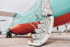 las puertas están abiertas. avión turbohélice estacionado en la pista durante el día foto